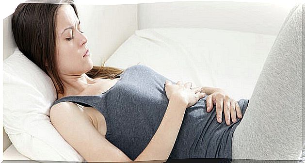 Woman has hands on her stomach because of stomach pain