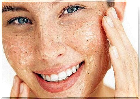 Smiling woman with an exfoliant on the face