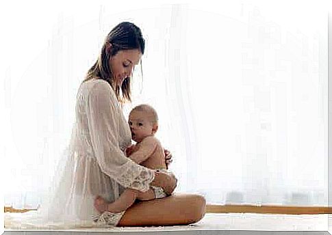 A woman holds a baby on her lap