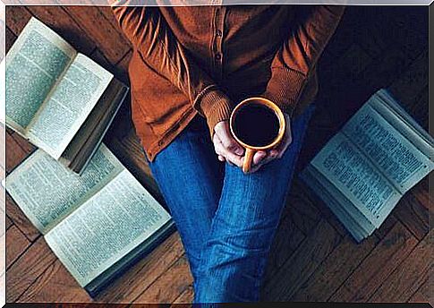 Woman with cup of coffee and books