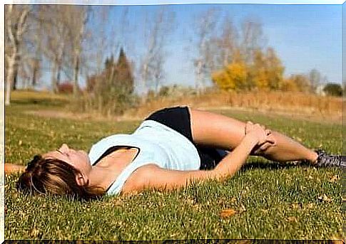 A woman doing abdominal exercises in the grass