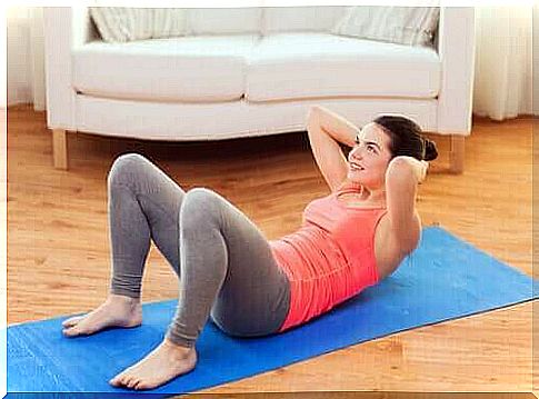 A woman does abdominal exercises on a yoga mat