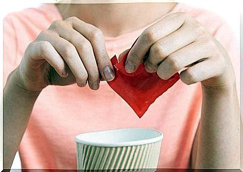 Woman opens sachet of artificial sweetener