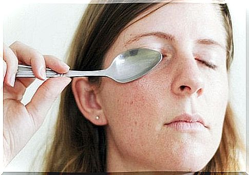 Woman presses cold spoon to eye