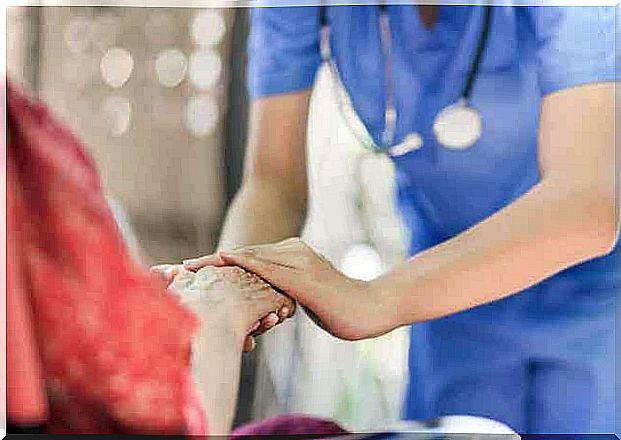 Caregiver holding elderly hand