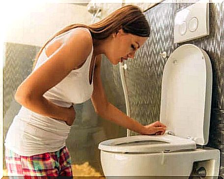 A woman throws up in the toilet bowl